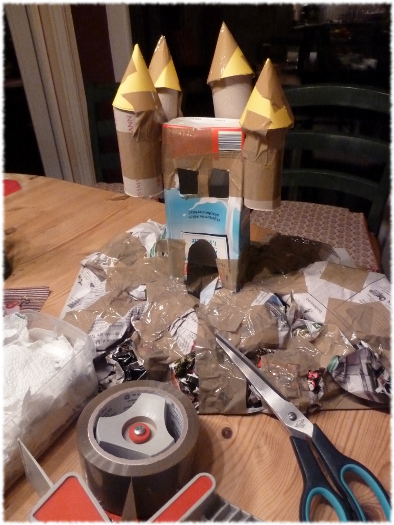 Auf eine Pappe zusammen geknülltes Zeitungspapier festkleben und das Schloß darauf befestigen.